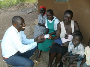 Amelia receives her hospital insurance card from Nicholas Odwar, Luo Care's administrator.